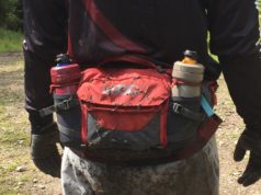 Mountain biker with the Hip Pack Pro 3L in carbon grey/chilli red around their waist