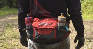 Mountain biker with the Hip Pack Pro 3L in carbon grey/chilli red around their waist