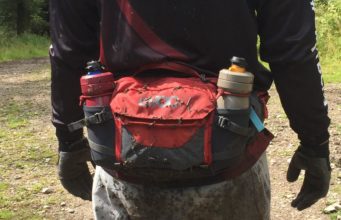Mountain biker with the Hip Pack Pro 3L in carbon grey/chilli red around their waist