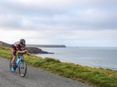 Triathlete on a bike on welsh coastline