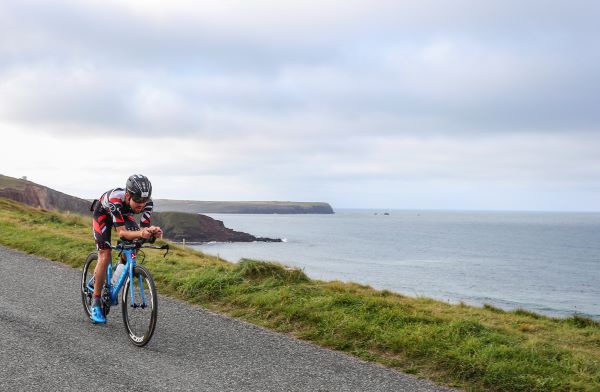 Triathlete on a bike on welsh coastline