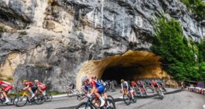 cyclists coming out of a rocky tunnel