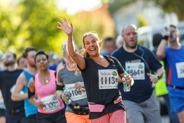 Smiling female runner waving at the camera