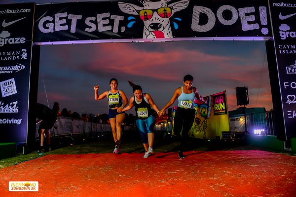 Runners crossing the finish line at sunset