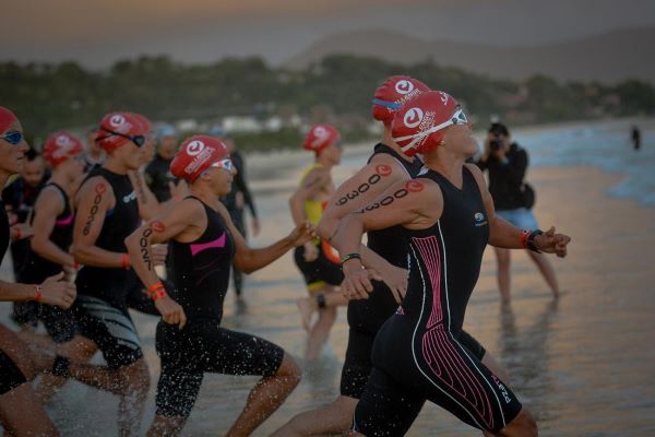 Female triathletes race towards the sea to begin their swim