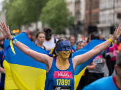A runner wears a Ukrainian flag and face paint as she takes part in the ‘Run for Ukraine’ wave.