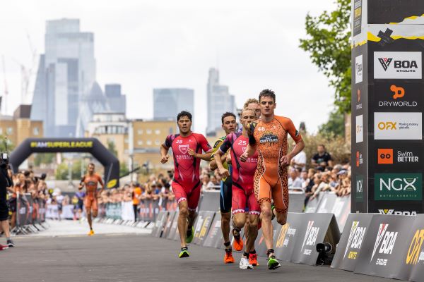 5 triathletes race together with the London skyline as a backdrop