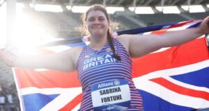 Sabrina Fortune smiles as she holds the Union flag behind her with outstretched arms