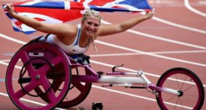 Sammi Kinghorn is pictured in her pink racing wheelchair holding the Union Flag aloft.