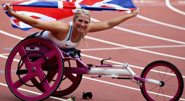 Sammi Kinghorn is pictured in her pink racing wheelchair holding the Union Flag aloft.