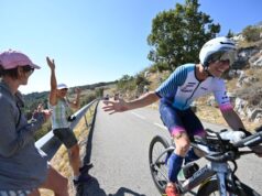 Cyclist high fiving two spectators on a winding mountain climb
