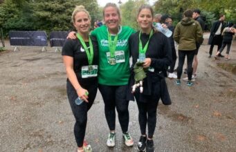 Three ladies in running kit smile, with medals around their necks