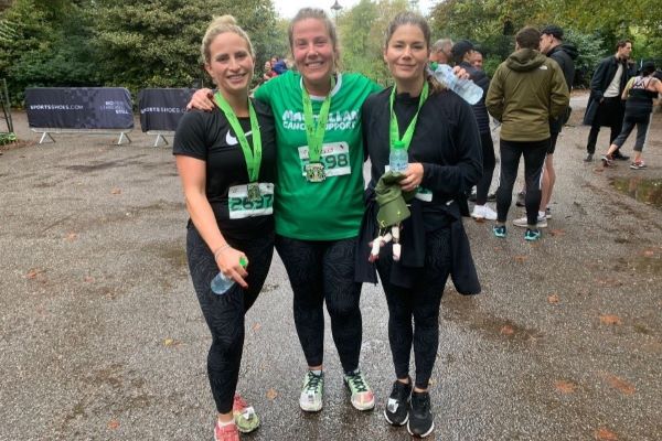 Three ladies in running kit smile, with medals around their necks