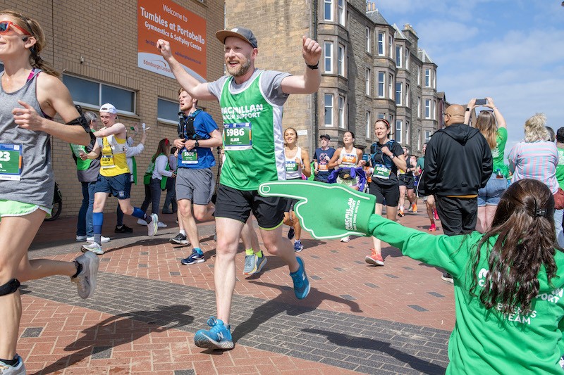 Runners in the Southampton marathon running in their macmillan green vests.
