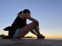 Photo of Liz sat on the pavement post run watching a lovely clear sunset