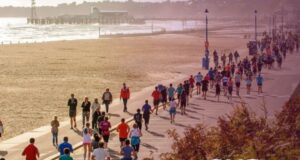 Runners along a sunny prom by the sea
