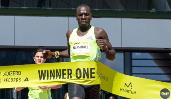 Man runs through yellow finish tape with the words Winner One