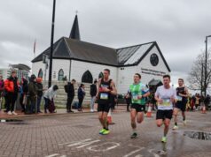 male runners in front of a quaint white church