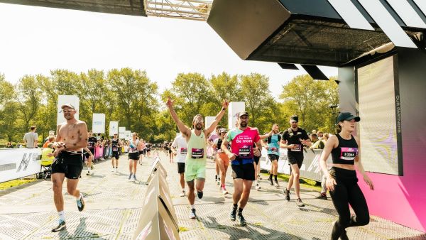 Runners cross the finish line with arms in the air