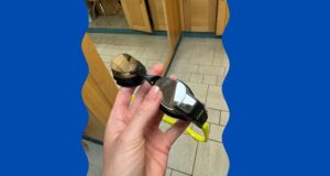 FORM smart goggles held in a persons hand in the changing room of the swimming baths.