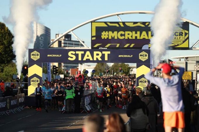 start line of the manchester half marathon with runners under a START line gantry