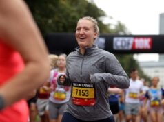 Female runner in grey long sleeve top smiles broadly