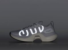A grey running shoe with reflective detail against a grey background