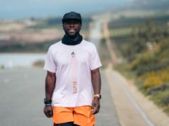 Man stands on African road in running kit