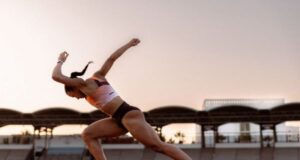 Woman springs off the block on a track looking immensely powerful