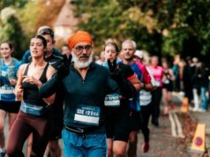 Man in orange turban stands out amongst a crowd of runners