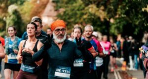 Man in orange turban stands out amongst a crowd of runners