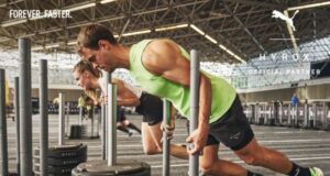 Man and woman push weights plates on a gym sled