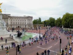 Runners run past Buckingham Palace in London