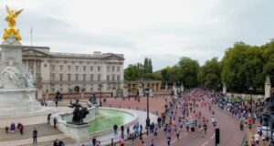 Runners run past Buckingham Palace in London