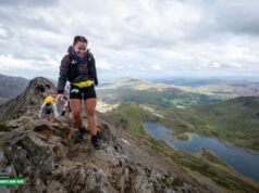 Woman crosses a very high rocky ridge
