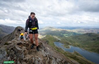 Woman crosses a very high rocky ridge
