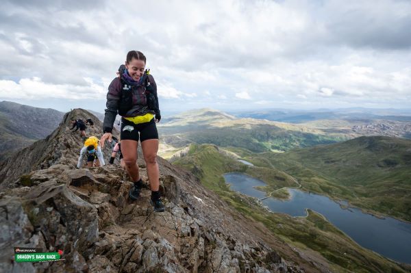 Woman crosses a very high rocky ridge