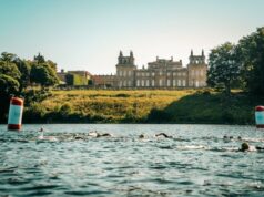 Swimmers in a lake in front of a palace