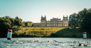 Swimmers in a lake in front of a palace
