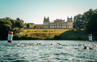 Swimmers in a lake in front of a palace