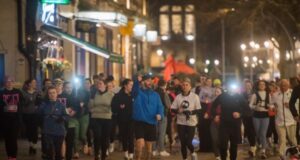 Male and female runners in a city at night
