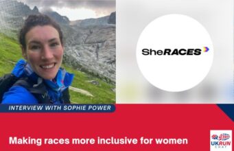 A female runner in a blue jacket smiles at the camera. Graphic also shows SheRACES logo and the words Interview with Sophie Power: Making races more inclusive for women.