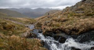 A lone male runner in an expansive and deserted moorland landscape