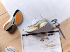 White, ornage and yellow running shoes on a wooden table with a sheet showing all the spec of the shoes