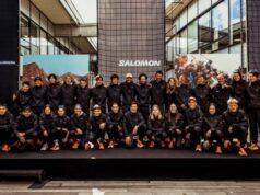 Team of athletes all wearing black kit pose for a formal group photograph