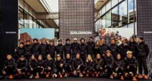 Team of athletes all wearing black kit pose for a formal group photograph