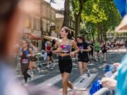 Woman in running kit runs through strets as part of race