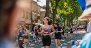 Woman in running kit runs through strets as part of race