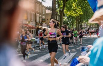 Woman in running kit runs through strets as part of race