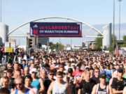 Thousands of runners in the start area of Manchester Marathon, under a banner which reads UK's largest day of marathon running